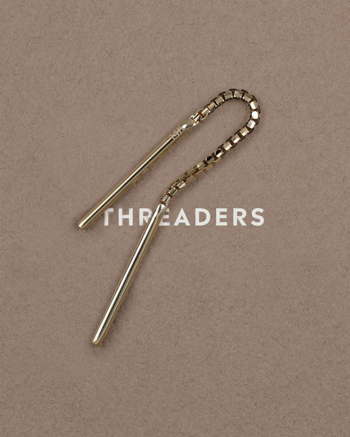 Gold brillcut short threader displayed on biege textured surface with the text THREADERS in the middle