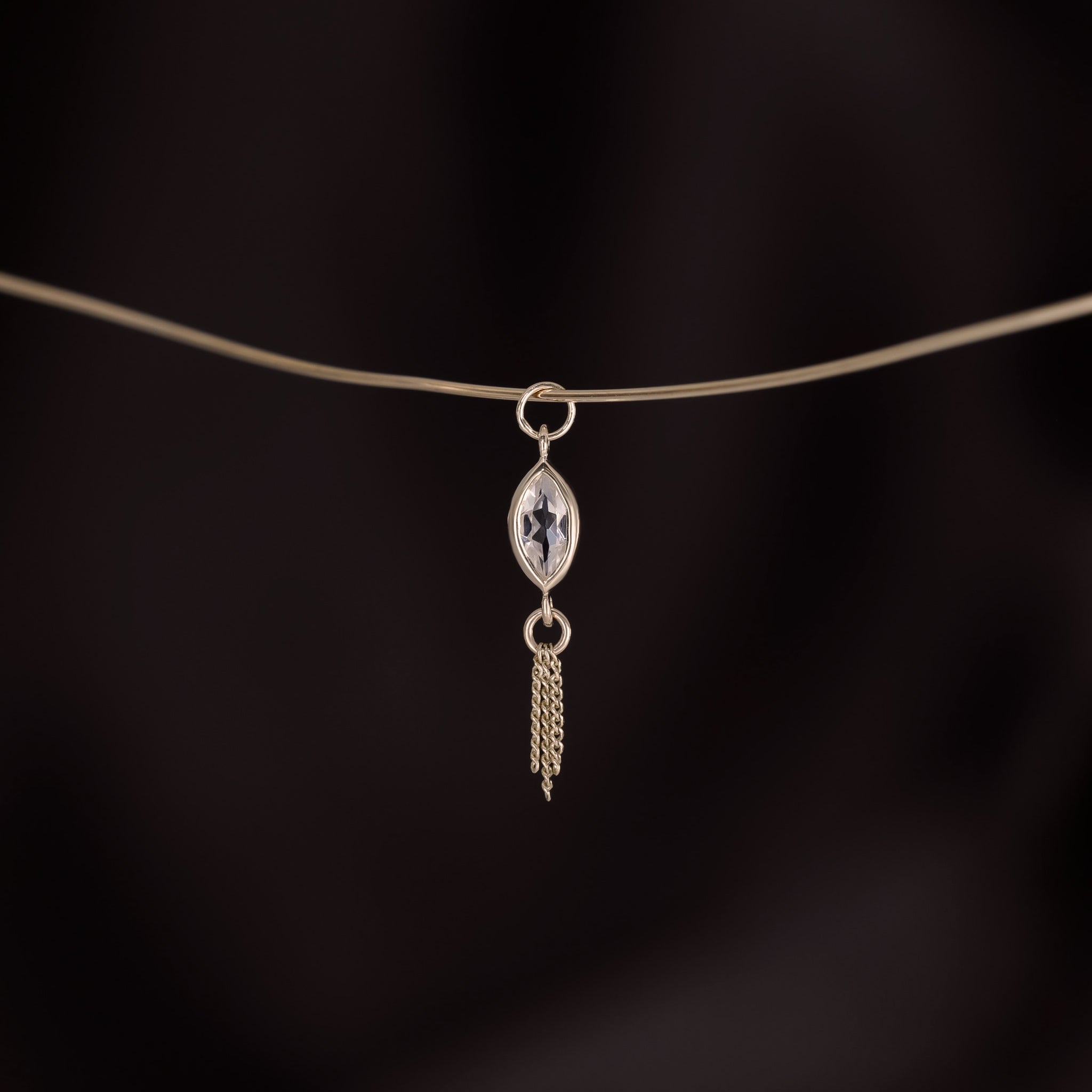 14K gold charm of a a marquise-cut White Topaz paired with three delicate gold curb chain tassels