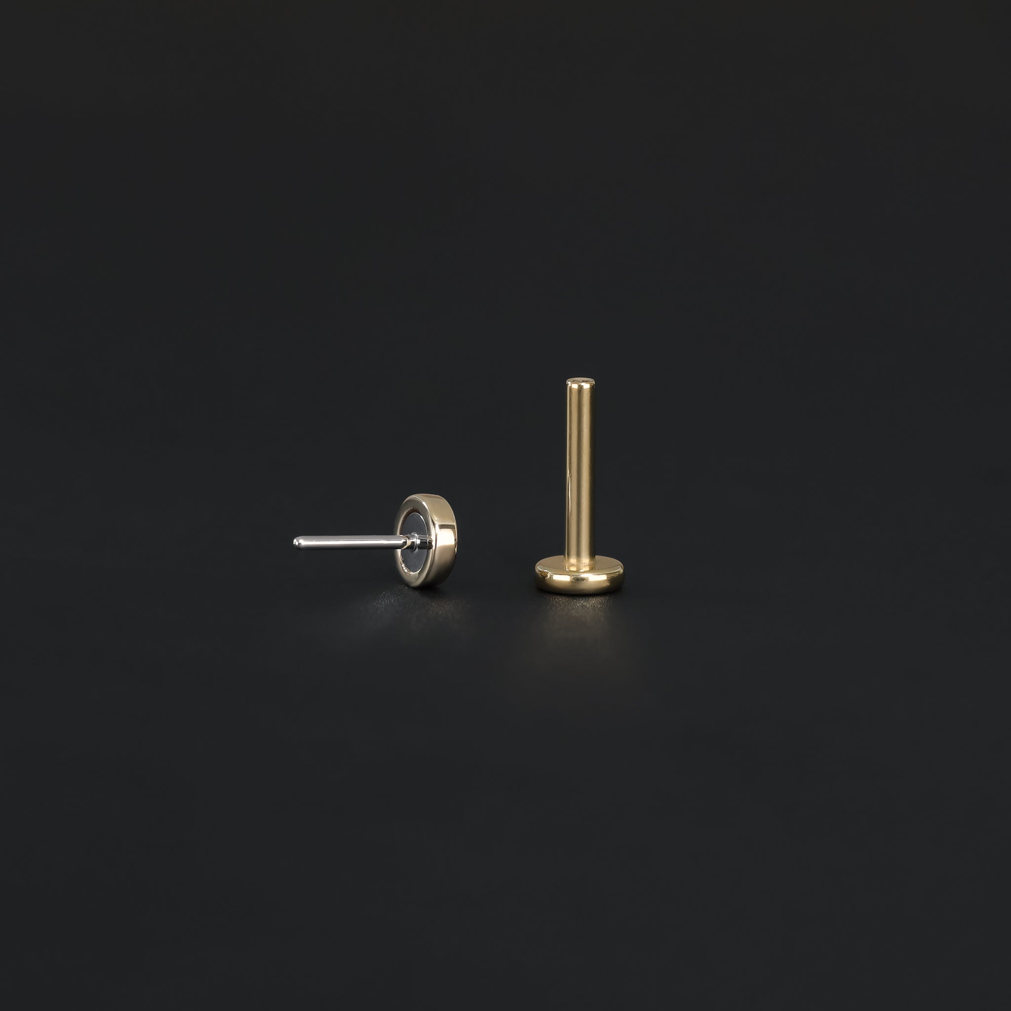 Push pin of 14K Gold Hammered disc studs in yellow gold back view and Titanium post displayed on black surface.