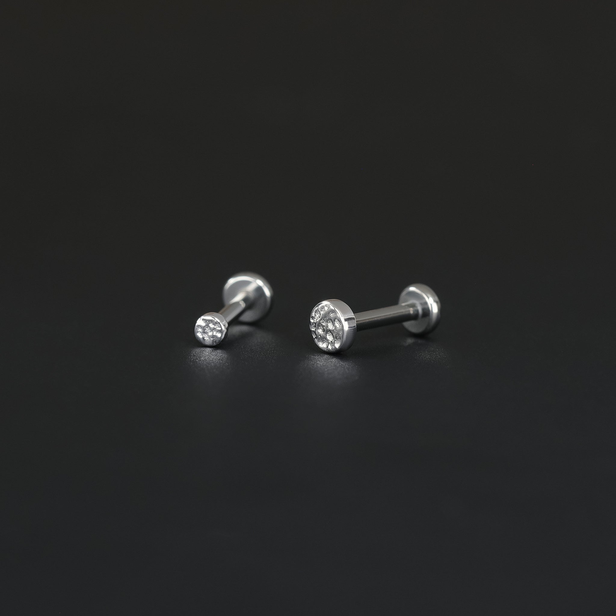 2mm and 3mm 14K Gold Hammered disc studs in white gold displayed on black surface.