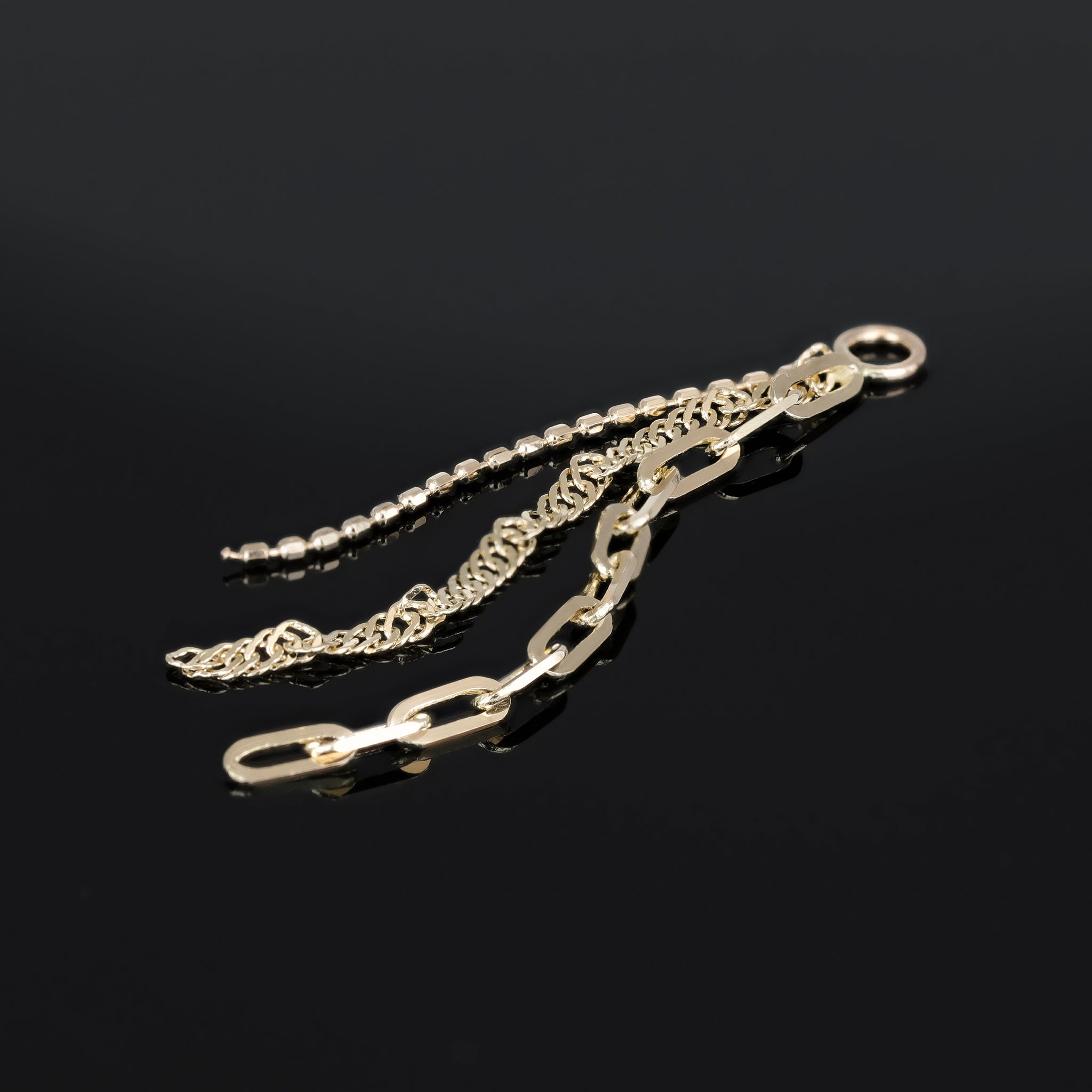 14K yellow gold mixed chain charm that comes with clip chain, box chain and Singapore chain displayed on black surface